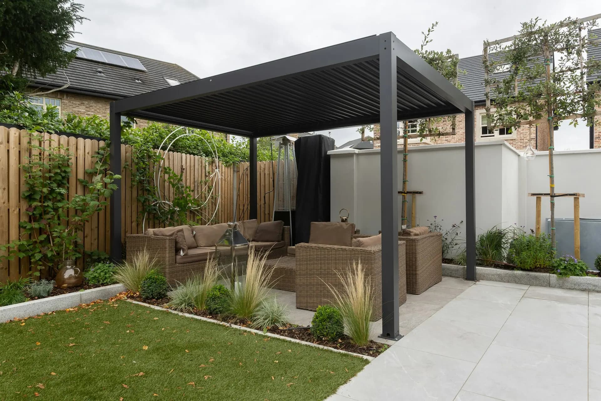 A modern garden structure with a slatted roof, set against a clad rear elevation