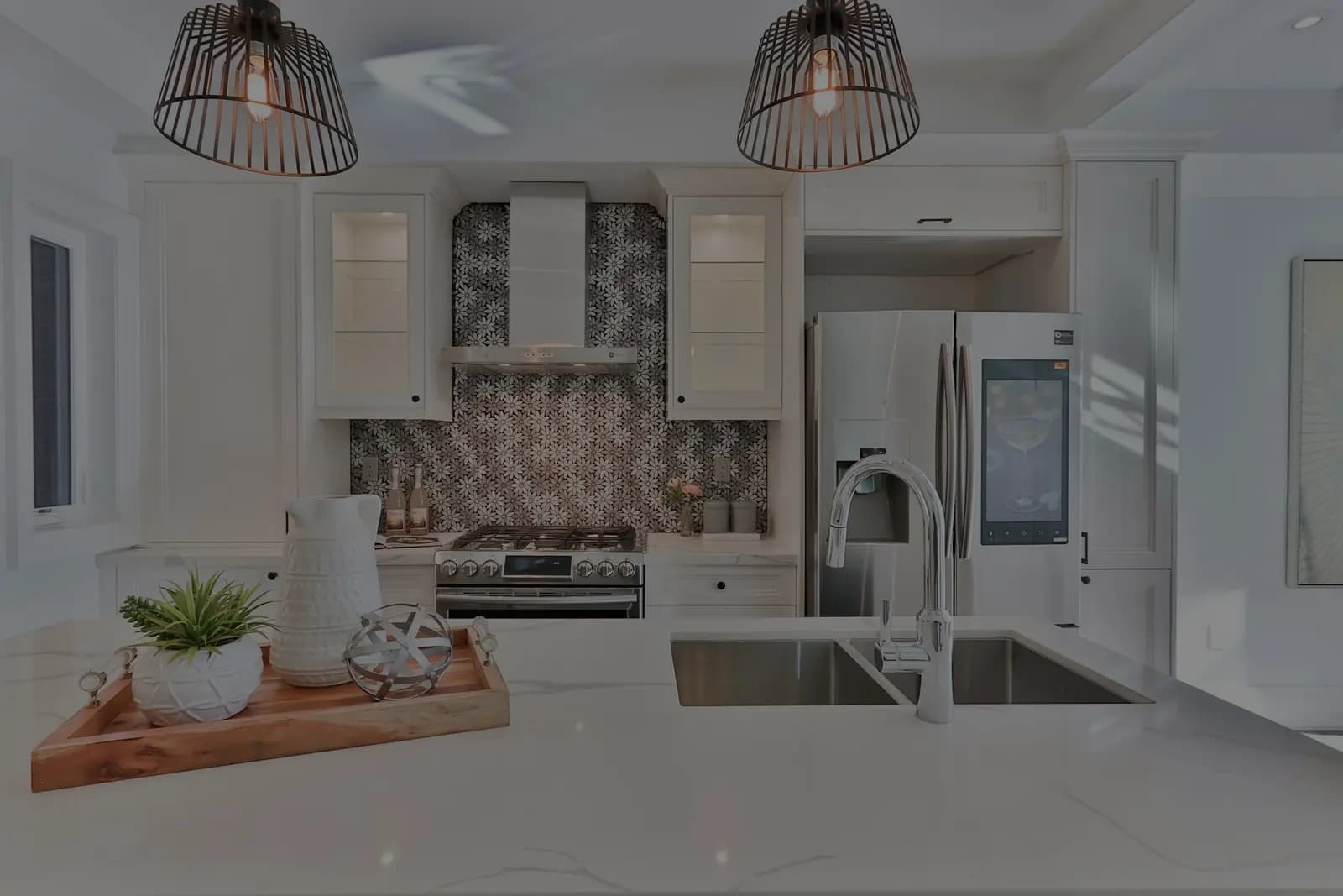 A fitted kitchen with a stone worktop, a patterned splashback and an integrated fridge